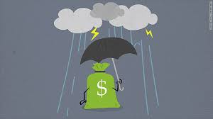 A person standing under an umbrella during heavy monsoon rain, while holding a piggy bank—symbolizing financial protection